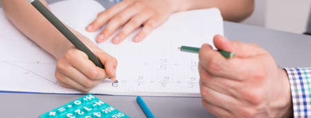 Little boy doing his difficult homework with father