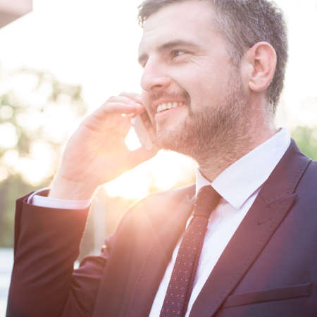 Smart middle aged businessman purchasing the client on the phoneの写真素材