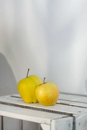 Shot of apples standing on a wooden table on a white backgroundの写真素材