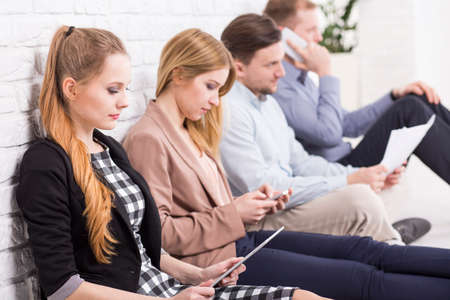 Young workers sitting leaned on the wall and concentrated on their tasks