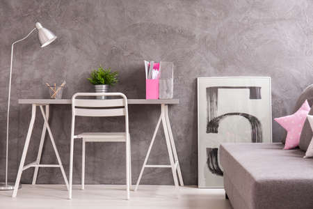 Minimalist teenager space with desk and comfortable couchの写真素材