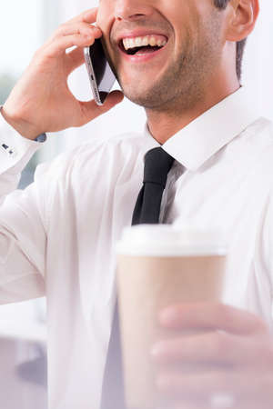 Closeup of a handsome business owner laughing on the phoneの写真素材