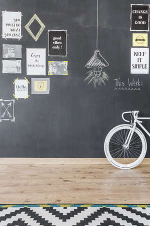 New style flat with chalkboard wall with motivational posters, bike and pattern carpetの写真素材
