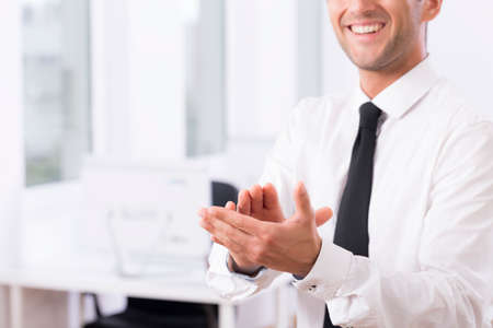 Cropped shot of a smiling male employee clapping handsの写真素材