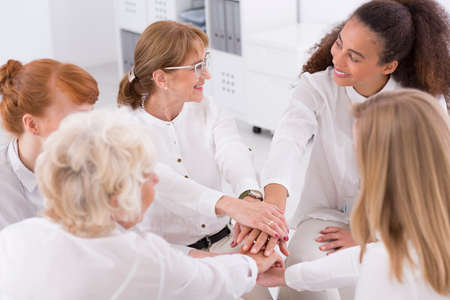 Cropped shot of a female co-workers doing unification gestureの写真素材