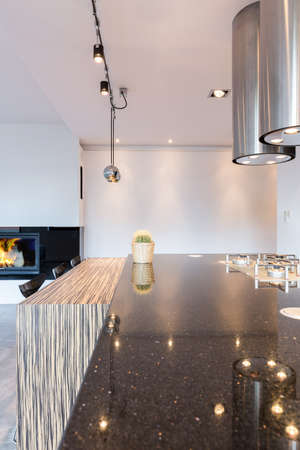 Minimalist kitchen with large countertop, modern lighting and eating barの写真素材