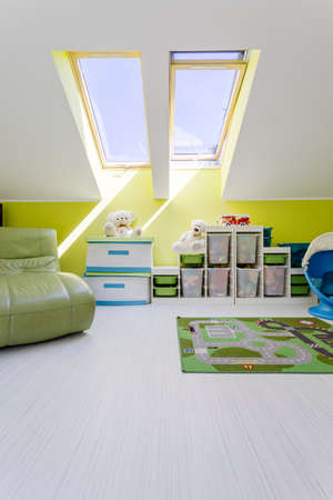 Modern style attic child room in white and green with sofa and new storage unitの写真素材
