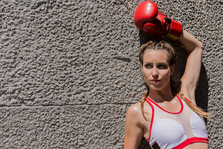 Cropped shot of a sports model leaning on the wall and looking in the distanceの写真素材