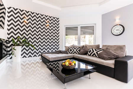 New style spacious living room with large sofa, black small table and pattern wallpaper