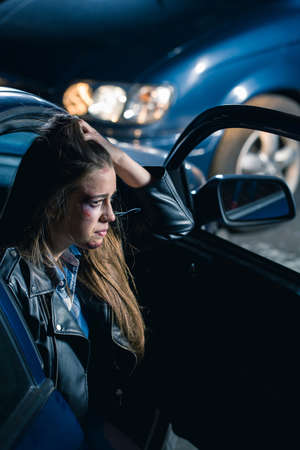 Terrified woman sitting on a passenger's seat on a place of an accidentの写真素材