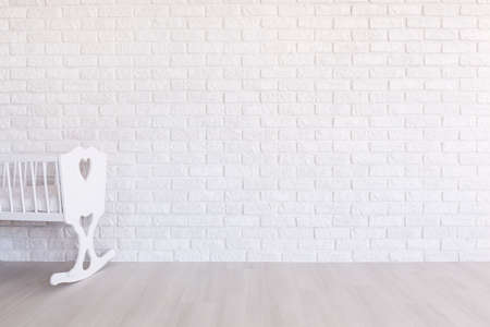 White cradle on the background of a white brick wallの写真素材