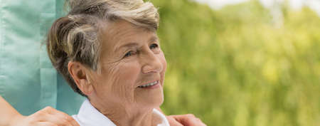 Portrait of cheerful elderly woman in the city parkの写真素材