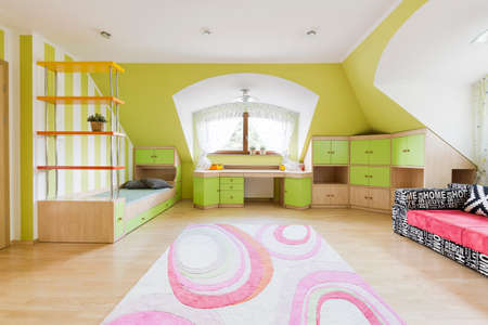 New design child room in green and white with pink carpet and cool pattern sofaの写真素材