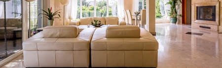 Panoramic shot of a spacious living room with leather furniture setの写真素材