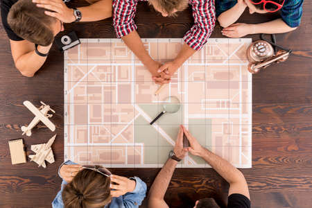 Young men and women discussing about their future tripの写真素材