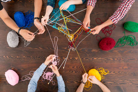 Wooden tabletop with colorful crewel and knitting needleの写真素材