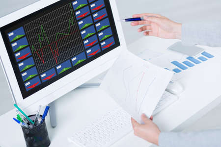 Employee working at the desk with reports and analysing the data