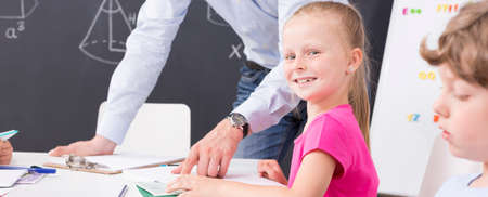 Schoolgirl learning math at the desk in the classroom