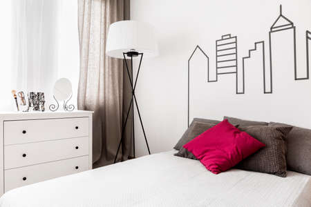 Bright room interior with bed set close to the white commodeの写真素材