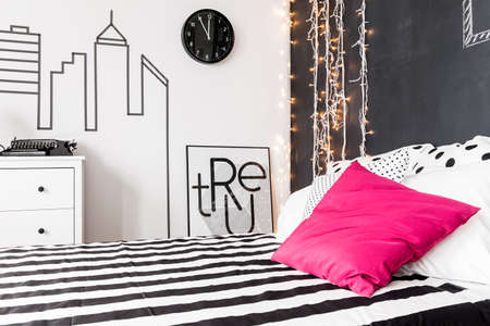 Closer shot of a bedrrom with wide bed with one pink pillow on itの写真素材