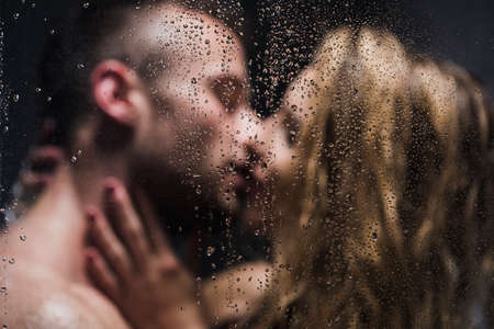 Blurred image of a sexy pair kissing in the showerの写真素材