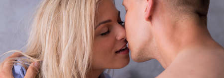 Woman in a male shirt and a man are passionately kissing