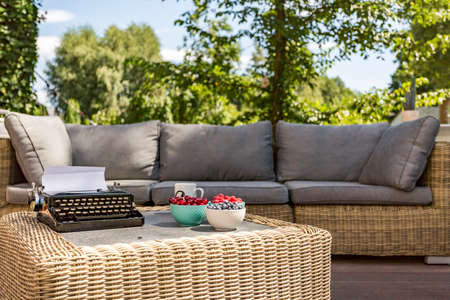 Image of an outdoor rattan sofa and coffee tableの写真素材