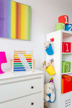 Room corner with white commode, rack and soft toysの写真素材