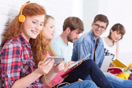 Five friends sitting at the academy corridor during the long breakの写真素材