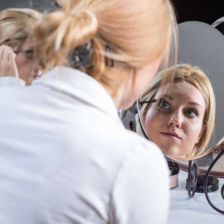 Young bride improves make-up before the weddingの写真素材