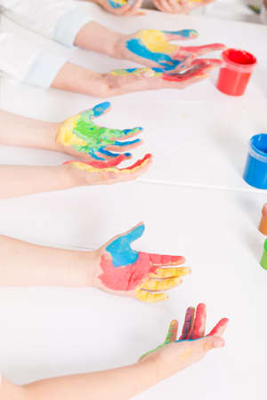Close-up of children's hands dirty with colourful paint during some kind of art classesの写真素材