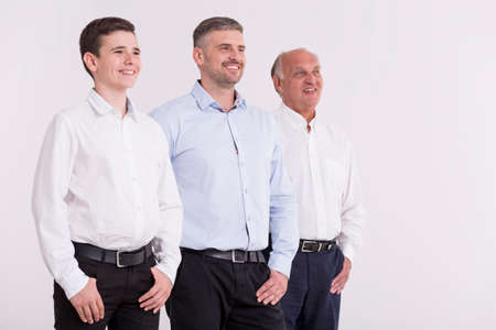 Shot of a men standing next to each other and smiling, looking in the distance