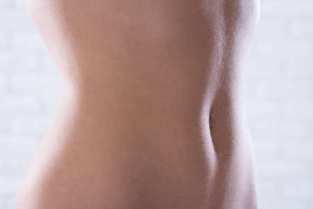 Fit woman's tummy isolated on a light backgroundの写真素材