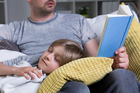 Shot of a man reading a book to his sonの写真素材
