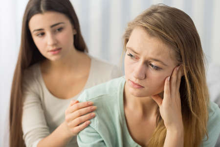 Despair teenage girl and friend supporting herの写真素材