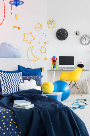 Cosy room for a young astronaut boy with cosmic themes on the walls and beddingの写真素材