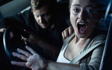 Killer breaking into a car of a terrified young woman