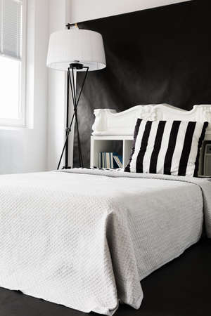 Black and white ascetic style bedroom with large bed and floor lampの写真素材