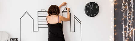Shot of a woman decorating a white wall with the washi tapeの写真素材