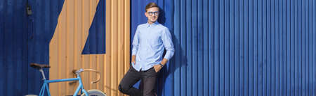 Stylish hipster young man and his blue bicycleの写真素材