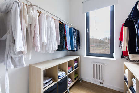 Dressing room with hangers and wooden chests of drawersの写真素材