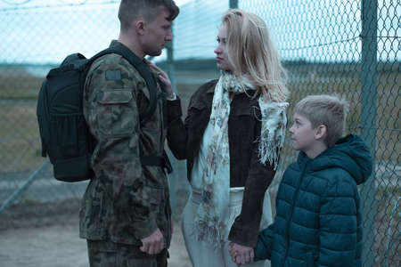 Family of a young soldier saying goodbye to him in a military areaの写真素材