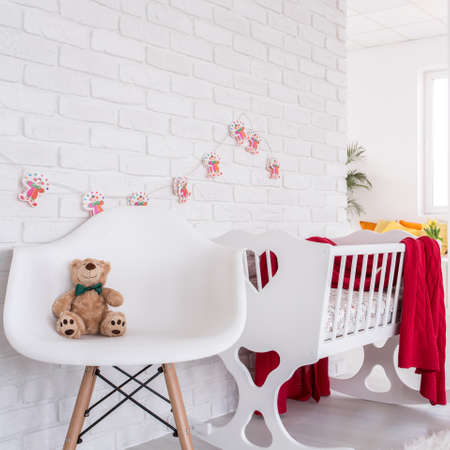 Shot of crib and a chair with a teddy bearの写真素材