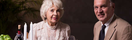 Beautiful panorama of a very elegant elderly couple having a romantic dinner togetherの写真素材