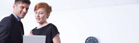 Young businesswoman shows her colleague from work something in documentsの写真素材