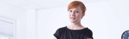 Focused and full of professional businesswoman is standing with folded arms