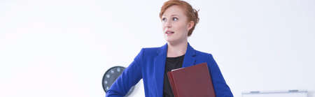 Young engaged and focused businesswoman is holding a briefcase with documentsの写真素材