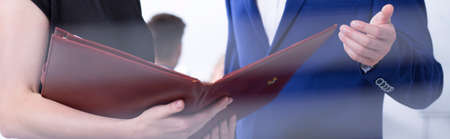 Close-up on young office workers discussing with commitment about documentsの写真素材