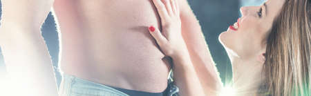 Smiling woman is kneeling in front of a man with a bare chestの写真素材