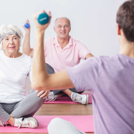 Active seniors lifting the dumbbells during fitness classesの写真素材